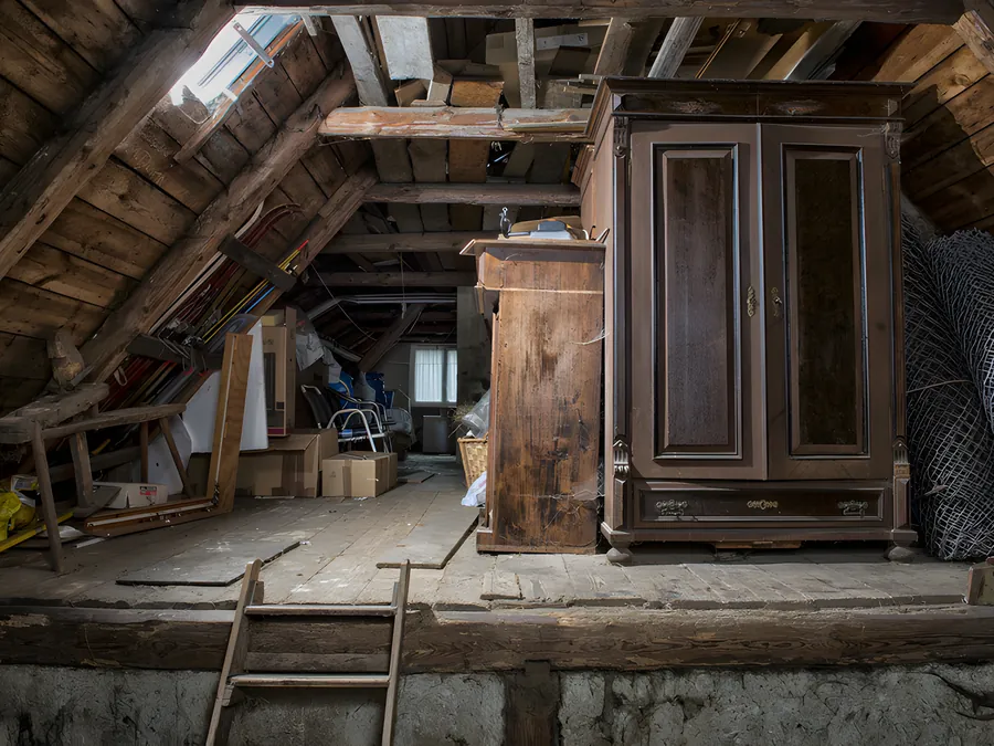 Dachboden mit altem Schrank und Kisten vor der Entrümpelung